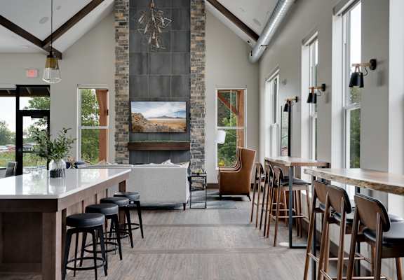 a large room with tables and chairs and a bar and a fireplace