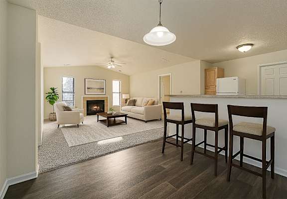 A living room with a fireplace and two chairs.