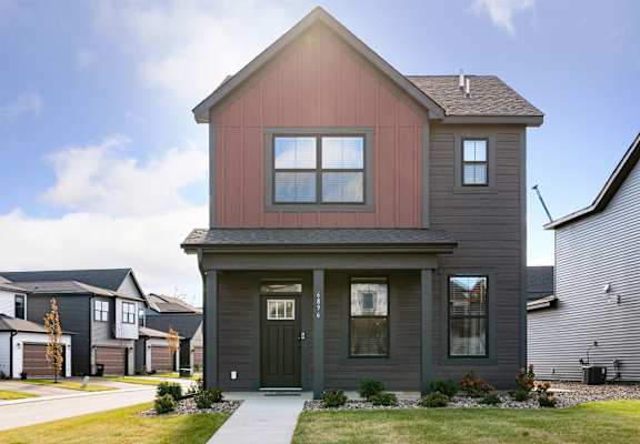 the front of a house with a sidewalk in front of it