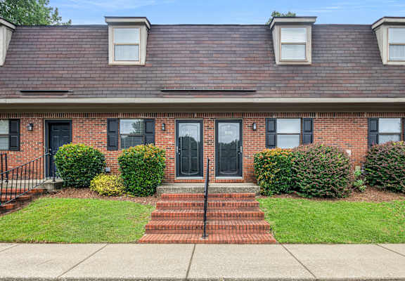 A red brick house with a black door and windows.