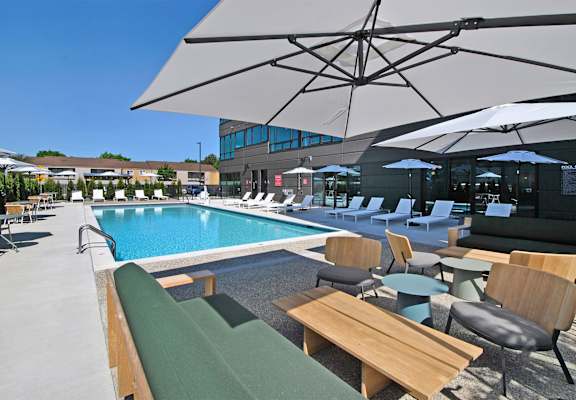 a swimming pool with lounge chairs and umbrellas at a hotel
