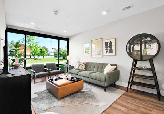 a living room with a couch and chairs and a large window