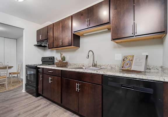 a kitchen with wooden cabinets and a counter top and a sink