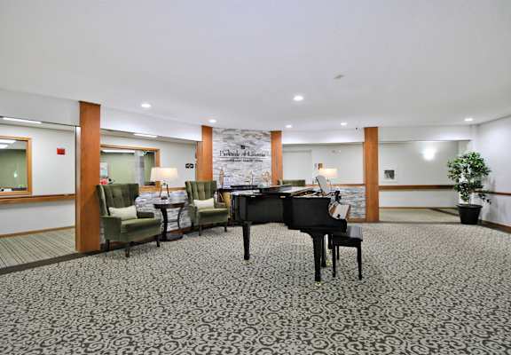 a large lobby with a piano and a table with chairs
