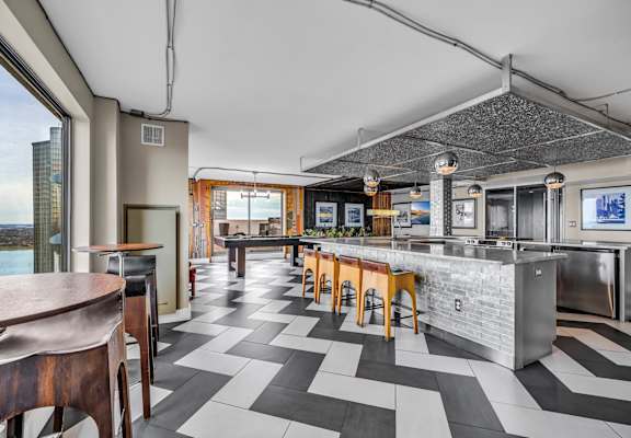 A modern kitchen with a bar area and a view of the city.