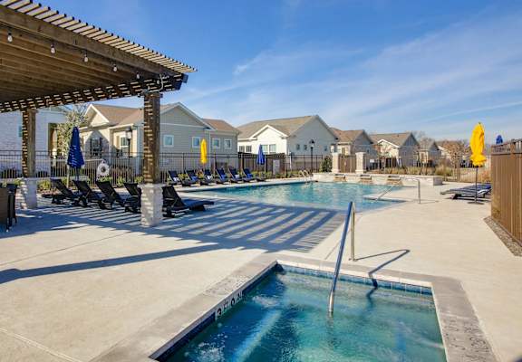 A large outdoor swimming pool with a slide and sun loungers.