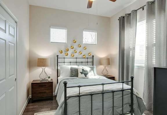A bedroom with a bed, nightstand, and a ceiling fan.