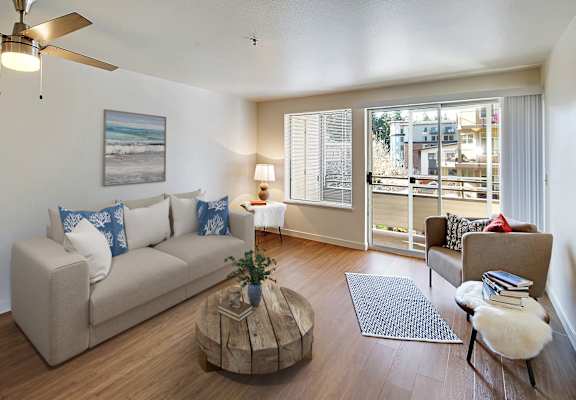 a living room with a couch and a chair and a sliding glass door at Townside Flats, Redmond, 98052