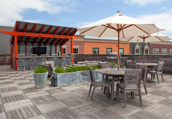 a roof deck with tables chairs and umbrellas  at Iron Works Sono, Norwalk, Connecticut