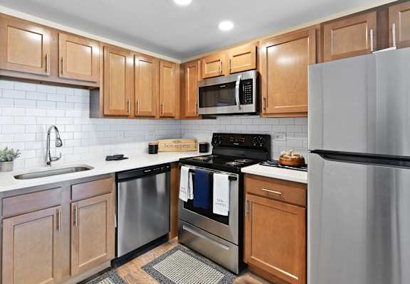 a kitchen with stainless steel appliances and wooden cabinets