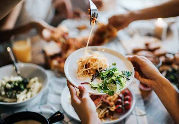 a group of people sitting around a table eating food with