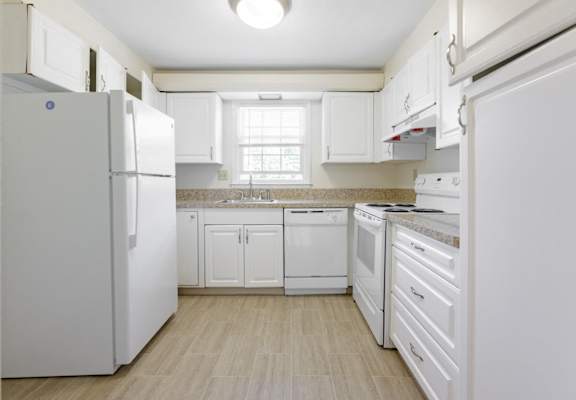 a white kitchen with white appliances and white cabinets