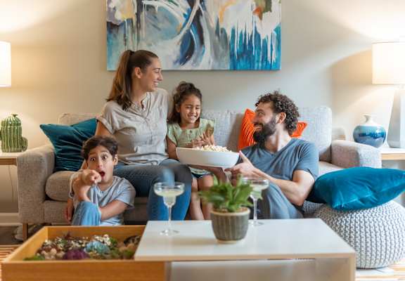a family sitting on a couch in a living room at Mason Street Townhomes, Grand Rapids, Michigan