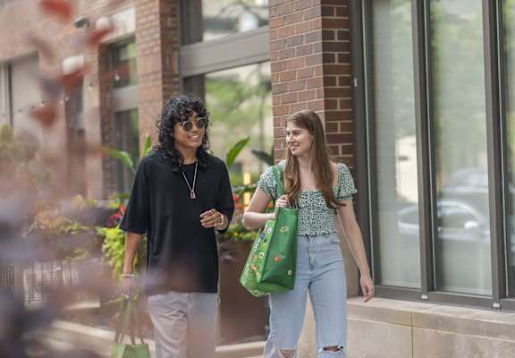 two women walking down the street talking to each other