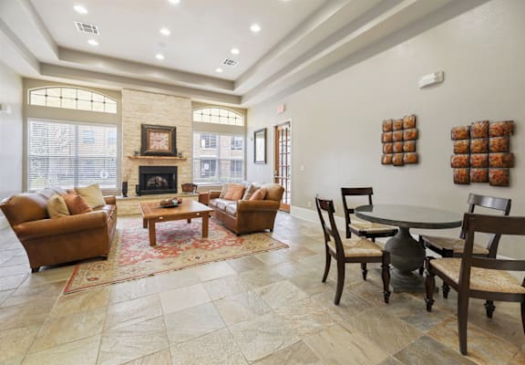 A living room with a fireplace and a dining table.