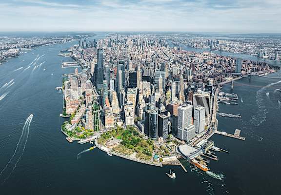 A cityscape with a large body of water in the foreground and a bridge in the background at Aria, New York, New York.