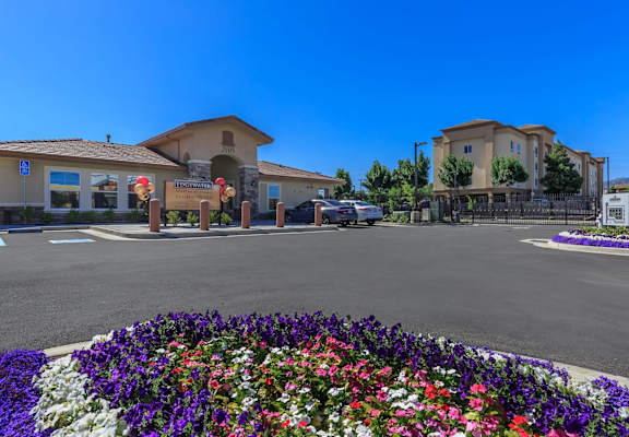A flower bed in front of a building with a sign that says at Edgewater, Pittsburg, CA