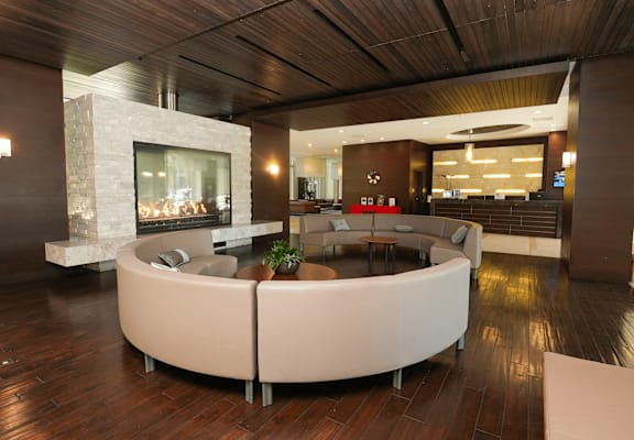A modern living room with a stone fireplace and a curved sofa.