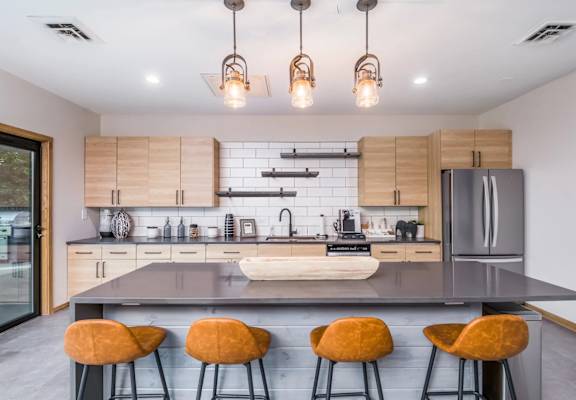 A modern kitchen with a large island and bar stools.