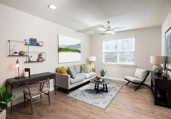 a living room with a ceiling fan and hardwood flooring at 55 Fifty at Northwest Crossing, Houston