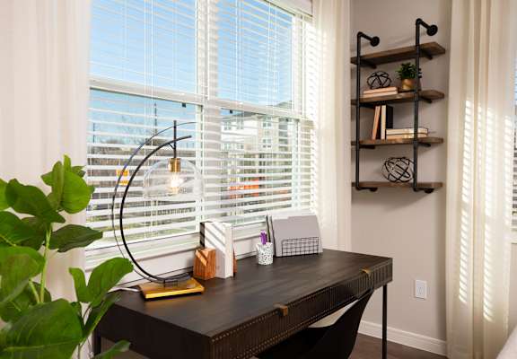 a home office with a large window and a wooden desk at 55 Fifty at Northwest Crossing, Houston Texas
