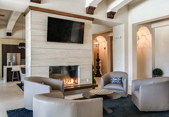 a living room with a fireplace and chairs