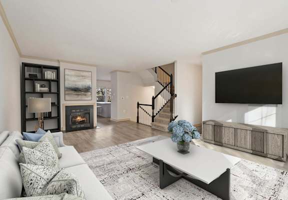 A modern living room with a fireplace and a staircase.