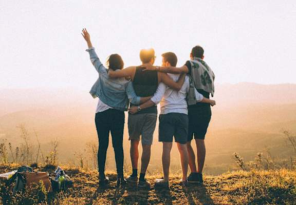 a group of people standing on a mountain with their arms around each other at Union Heights Apartments, Colorado