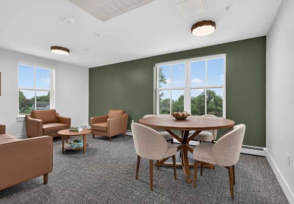 A room with a table and chairs and a window.