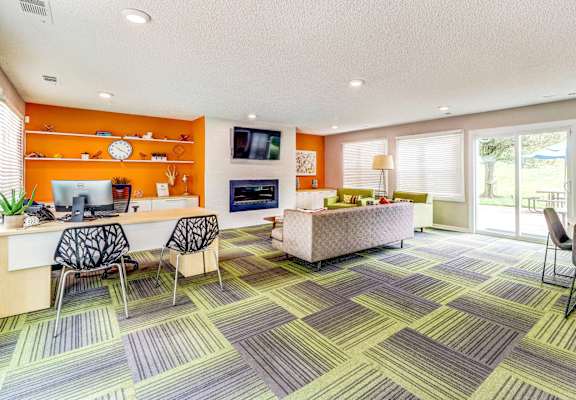 A room with a desk, chairs, and a couch.