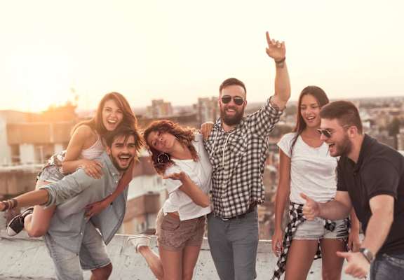 Friends Smiling and Having Fun Together on Rooftop