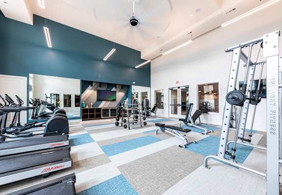 a gym with treadmills and other exercise equipment in a building with blue walls