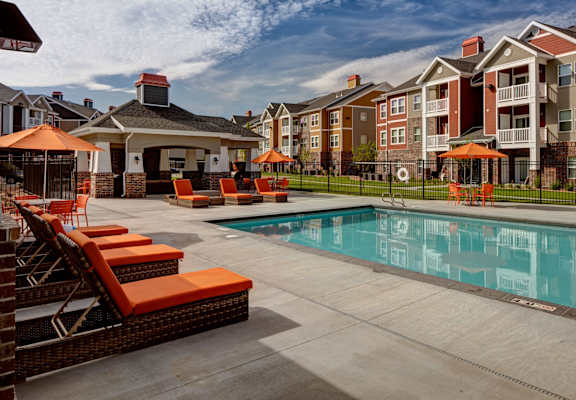 A pool area with orange chairs and a gazebo. at The Alloy at Geneva, Vineyard, Utah