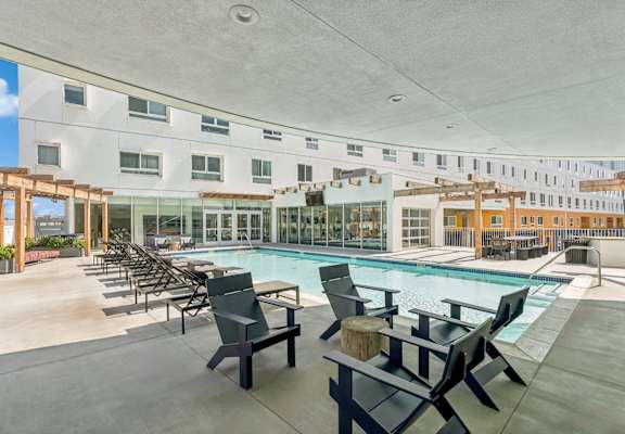 swimming pool with sun deck and covered lounging areas at One Santa Fe apartments
