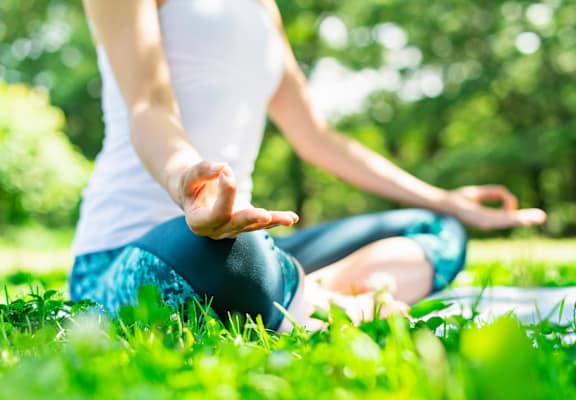 a woman doing yoga in a park