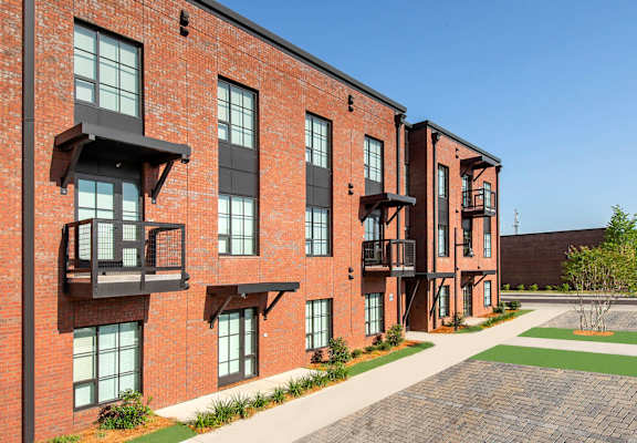 A red brick building with balconies and windows.