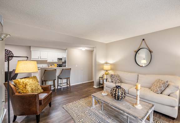 A living room with a white couch, a coffee table, and a lamp.