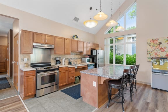 a kitchen with wooden cabinets and stainless steel appliances and a marble counter top