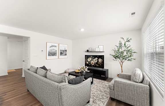 A modern living room with a black coffee table and a white sofa.