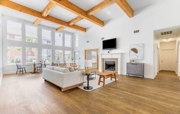 A spacious living room with wooden floors and a high ceiling.