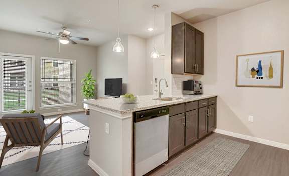 A kitchen with a white island and a ceiling fan.