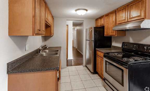 A kitchen with wooden cabinets and a black stove top oven.