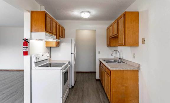 A kitchen with white appliances and wooden cabinets.