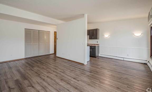 A room with wooden flooring and white walls.