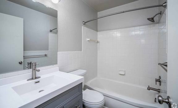 A white bathroom with a sink, toilet, and bathtub.