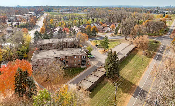 A large building sits in the middle of a grassy area with trees in the background.