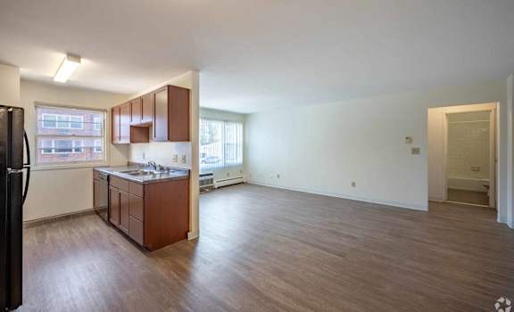 A kitchen with brown cabinets and a black refrigerator.