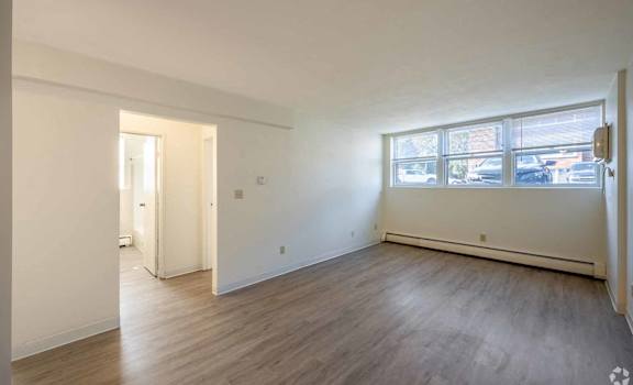 A room with wooden flooring and a large window.