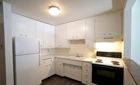 a kitchen with white cabinetry and black appliances