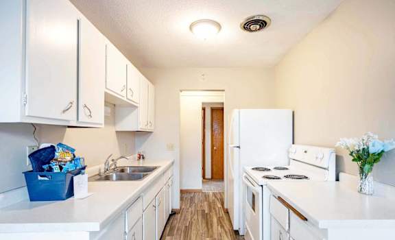 A kitchen with white appliances and cabinets.